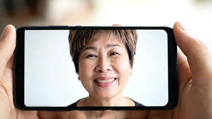 Mature woman portrait on smartphone screen held in human hands