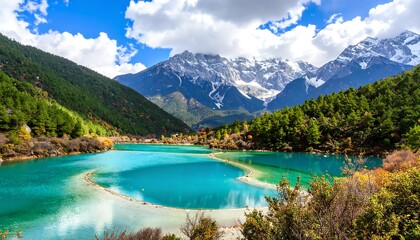 Fototapeta premium A breathtaking view of a turquoise lake surrounded by lush forests and majestic snow-capped mountains under a vibrant blue sky, showcasing natural beauty. 