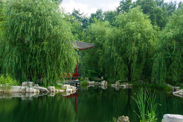 beautiful landscape of oriental garden with pond and gazebo among foliage © Evgeny