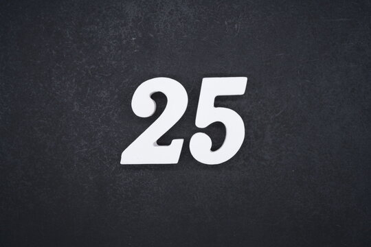 The numbers are made of white painted wood and placed on a black plastic background.