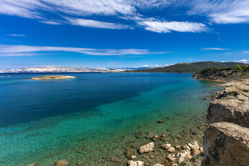 Azure water in the Adriatic Sea, rocky coast of the island of Rab, cloudy, threatening sky,