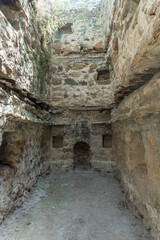 One of the rooms of the medieval fortress. Niches in the stone wall. Traces of the second floor are visible. Khuluti fortress. Georgia