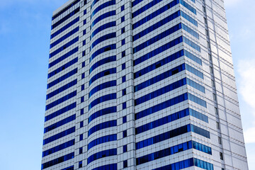Modern high-rise building with blue windows against clear sky