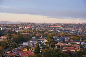 Obraz premium Aerial view of Johannesburg city centre at sunrise, South Africa. The skyline is bathed in warm morning light with urban streets, and a vibrant city atmosphere representing modern Africa.