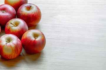 Red and yellow apples on wooden surface