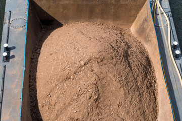 A boat carrying sand to be processed