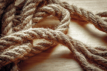 Close-up of coiled rough rope on wooden surface