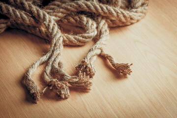 Close-up of frayed rope ends on wooden surface
