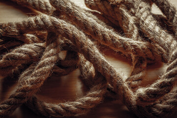 Close-up of twisted jute ropes on wooden surface with detailed texture