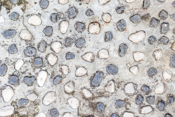 Close-up of textured stone and concrete surface with natural pebbles
