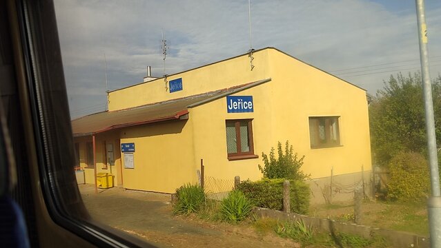 Train station building sign city town windows trane sky platform