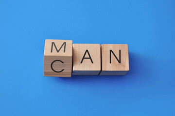 Motivational concept with wooden cubes showing words CAN and MAN, self belief and confidence...