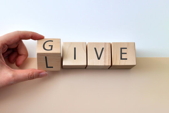 Wooden cubes with changing word Give Live, concept of generosity and life