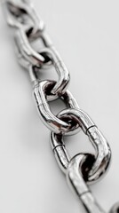 Obraz premium Detailed close-up of shiny metal chain links resting on a light surface with reflections
