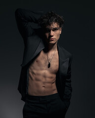 cool sexy fit man in black jacket showing chest and abs and posing