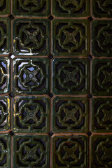 Intricate green ceramic tiles with floral patterns and glossy finish