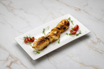 Golden baked pastry roll with cheese, served with cherry tomatoes and microgreens