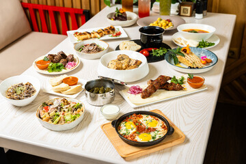 Traditional Middle Eastern dishes served on a white table in restaurant interior