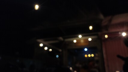 Night photo of warm glowing lights creating a cozy atmosphere in the dark. This image captures a...