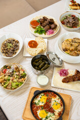 Traditional Middle Eastern dishes served on a white table in restaurant interior