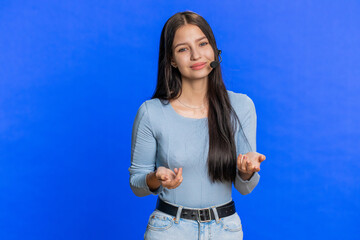 Caucasian young woman wearing headset, freelance worker, call center, support service operator helpline, having talk with client or colleague, communication support. Girl isolated on blue background