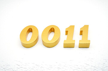 The numbers are made of gold-painted wood, placed on a white background.