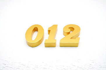 The numbers are made of gold-painted wood, placed on a white background.