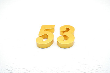 The numbers are made of gold-painted wood, placed on a white background.