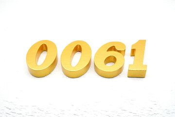 The numbers are made of gold-painted wood, placed on a white background.