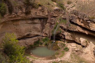 A small waterfall with a lake in the mountains.