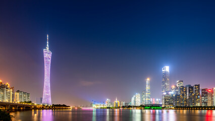 Night view of modern city skyline with tall skyscrapers and illuminated tower