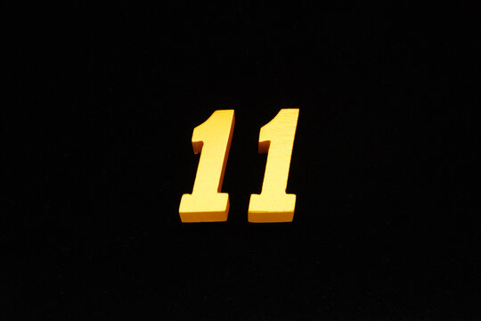 The numbers are made of gold-painted wood, placed on a black background.