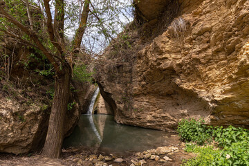 A small waterfall with a lake in the mountains.