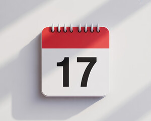 Fototapeta premium Calendar Page Displaying Number Seventeen on White Surface with Soft Shadows Casting a Minimalist and Modern Aesthetic Design