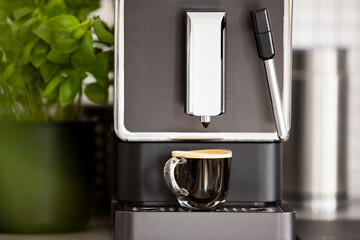 Close-up of a double espresso in a transparent glass cup made in a home coffee maker. Strong black...