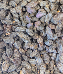 Dried black raisins stacked in bulk. Natural fruit background.