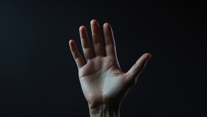 Hand against dark background with a gentle gesture.