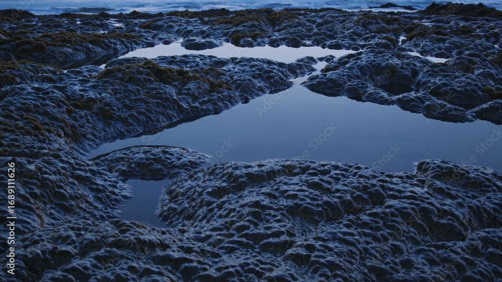 Poster serene tide pools reflecting the sky at low tide, creating a tranquil coastal scene at dusk with sha