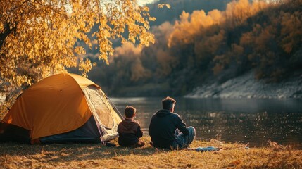 Father and son enjoy autumn camping by the river.