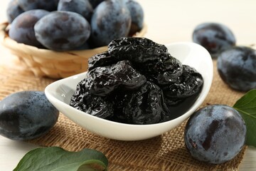 Dried prunes and fresh plums on table, closeup