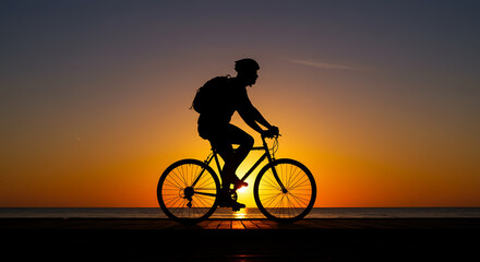 Obraz premium Silhouette of Cyclist at Sunset