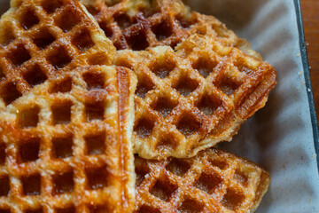 Macro close-up of freshly baked golden brown croffles with crispy texture and caramelized surface. Perfect food photography for illustrating breakfast, brunch, dessert, bakery, and homemade snack