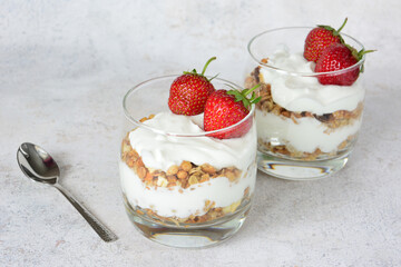 Strawberry Yogurt Parfaits in Glasses with Granola with a spoon