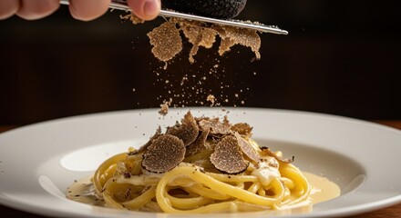 Pasta is topped with truffles using a grater