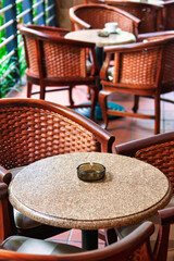 chairs and tables on the terrace of a restaurant , rattan wood furniture, intricate design,