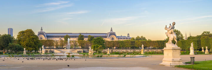 Early morning light illuminates Jardin des Tuileries with Musée d'Orsay in the background - Paris,...