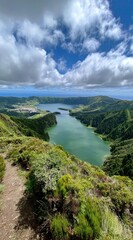 Fototapeta premium Verdant viewpoint Emerald lake nestled amongst green hills under a partly cloudy sky, showing a serene vista. Path and foliage foreground