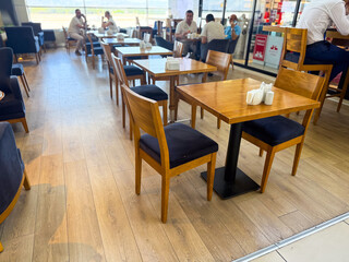 Cafe with wooden tables and people sitting in groups. Hospitality, lifestyle and social interaction in public dining environments.