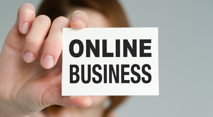 A person is holding a white card that says Online Business