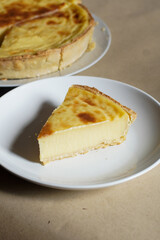 Custard Tart Slice on White Plate with Whole Tart in Background